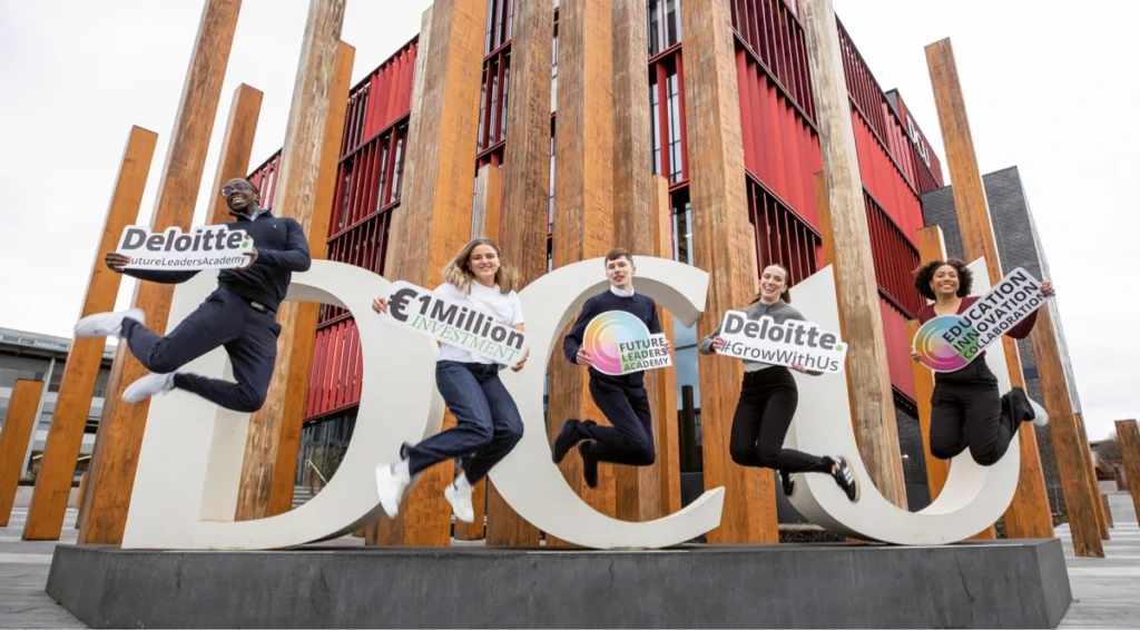 Group of students jumping in the air with signs