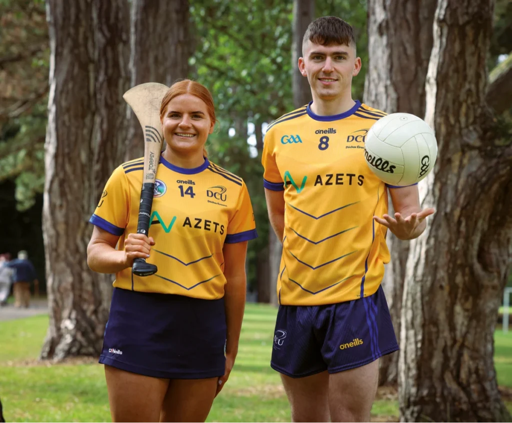 Picture of two DCU sports students holding a hurl and a football